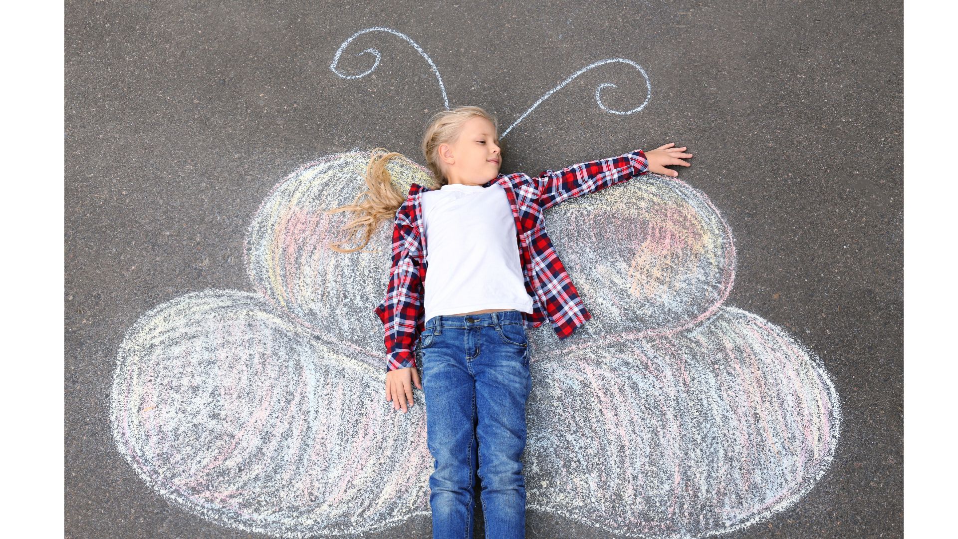 White girl with blond hair laying on a chalk drawing of butterfly wings.