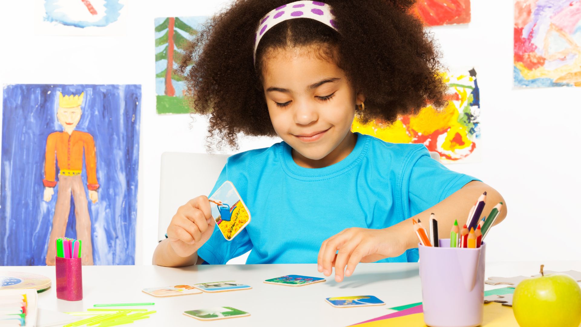 Young girl playing a matching card game at a table